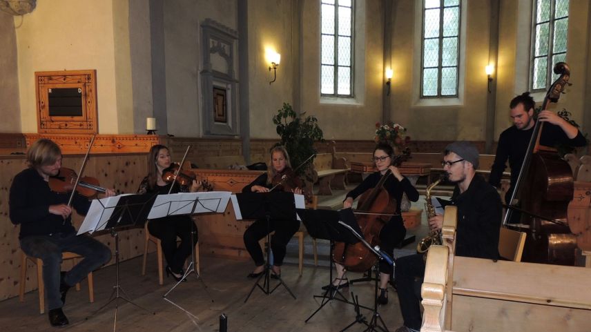 Musicistas e musicists in plaina concentraziun dürant il concert illa baselgia da Sent (fotografia: Benedict Stecher).