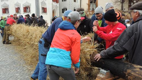 «L’Hom Strom es ün bel hom, ün hom da nom e pom.» In sonda davomezdi d’eiran magisters e scolars, dals plü pitschens infin pro’ls gronds, fatschendats da plajar las cuas da strom da sejel intuorn la latta (fotografia: Benedict Stecher).