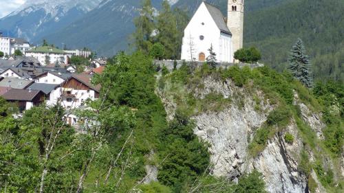 La baselgia San Geer es situada sül grip sur las chasas da Scuol Sot ed eir sur l’En (fotografia: Flurin Andry).