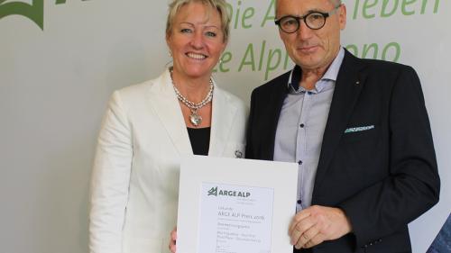 Regierungsrätin Barbara Janom Steiner gratuliert Arge-Alp-Preisträger Not Carl vom Projekt «Mia Engiadina» (Foto: Arge Alp). 