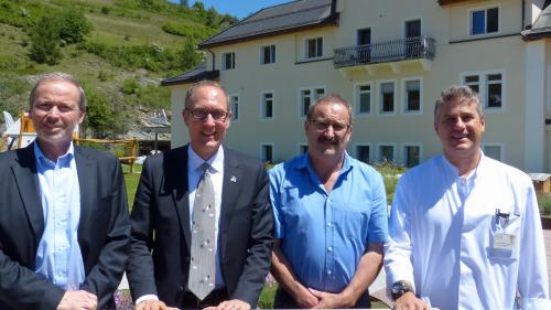 Philipp Gunzinger, Christian Rathgeb, Victor Peer e Joachim Koppenberg (da schnestra) davant l’ospidal regiunal a Scuol chi’d es exemplaric eir per oters ospidals (fotografia: Flurin Andry).