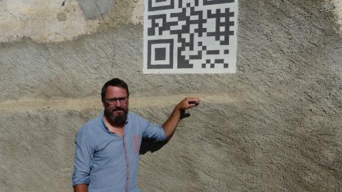 Curdin Tones davat sia chasa a Tschlin chi ha sü in fuorma da sgrafit ün QR-Code (fotografia: Flurin Andry).