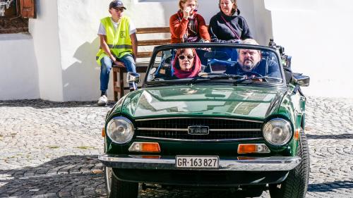 Bestatter Luc Conrad (Mike Müller) fährt mit seiner Berufskollegin Sonja Lardelli (Mona Petri) für Dreharbeiten durch Scuol. Foto: Jon Duschletta