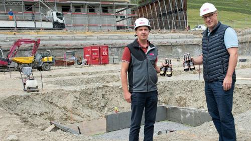 Bauführer Remo Albertin von der Firma Rocca und Hotz Bau (links) und Daniel Käslin mit den Bieren, die anlässlich der Grundsteinlegung beim Gewerbehaus Serlas einbetoniert worden sind. Foto: Reto Stifel