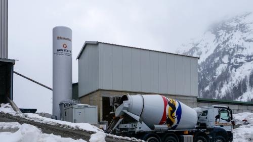 Schlank und rank: Die Neustark-Speicheranlage zur Reduktion von CO2 in Recyclingbeton auf dem Werksgelände der Montebello AG in Pontresina mit Silo und Technikcontainer. Dazwischen der Verdampfer. Foto: Jon Duschletta
