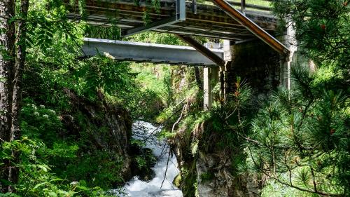 Blick von unten auf die grenzbildende Punt Ota bei Brail mit dem Gebirgsbach Ova da Punt Ota (links) und Blick von der eigentlichen Grenzbrücke auf die darunterliegenden Strassenbrücken der Engadinerstrasse. Fotos: Jon Duschletta