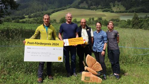 La surdatta dal premi: Florian Flechsig, silvicultur, Daniel Pitsch, vicepresident cumünal, Rinaldo Lechthaler,  suprastant, Melanie Schmid, Posta ed Anna Kocher, Schweizer Wanderwege (fotografia: Martin Camichel).