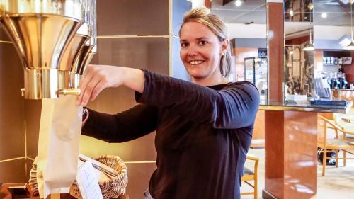 Geschäftsführerin Sabina Cloesters füllt bei der Erlebnisinsel Kaffeebohnen ab. Foto: Jon Duschletta