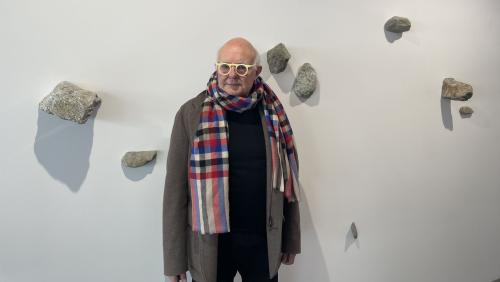 Rolf Sachs vor seiner Kunstinstallation mit Inn-Steinen. Foto: Gianina Flepp