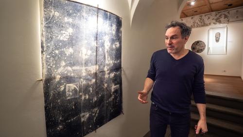 Michael Günzburger im Museum Engiadinais in St. Moritz mit einem seiner Drachenwerke, entstanden auf Basis von Museumsexponaten, wie zum Beispiel einer Tischoberfläche. Fotos: Jon Duschletta