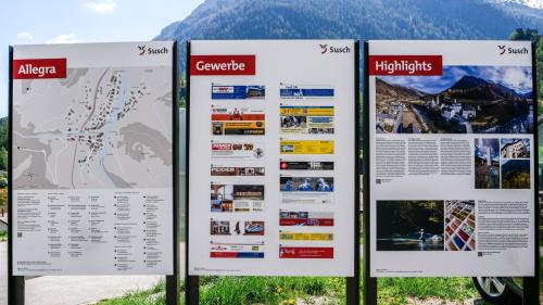 Las tablas d’infuormaziun a Susch infuorman ils giasts in lingua tudais-cha, francesa ed inglaisa (fotografia: Nicolo Bass).