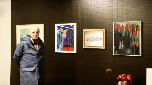 Der Initiator der Solidaritätsaktion, Peter Aronsky, anlässlich der Ausstellungsvernissage «Kunst für Hoffnung» im Kunstraum Riss vor Werken von Victora Schiro, Doris Sturzenegger und Urs Pfister. Foto: Jon Duschletta