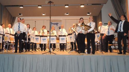 Musicantas e musicants da la Musica Concordia Müstair giodan l’applaus merità davo lur concert. A dretta Roberto Donchi. fotografia: Benedict Stecher