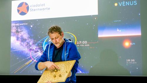 Jürg Kurt, der Leiter der Sternwarte «viadalat», gab während der AstroStunde Einblick in die aktuell spannende Konstellation der Planeten des Sonnensystems. Im Hintergrund oben das neue Logo der Sternwarte. Foto: Jon Duschletta