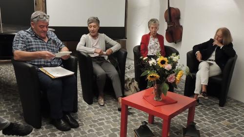 Armon Parolini cun Valerie Dolfi, Bernadette Bezzola e Mia Mathis han orientà davart l’istorgia da la biblioteca populara a Scuol (fotografia: Benedict Stecher).