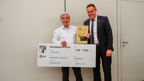Guido Christoffel (a Schnestra) cul premi d'energia 2024 da Zernez Energia 2020 dotà cun 1000 francs. A dretta il president cumünal Domenic Toutsch. fotografia: Jon Duschletta