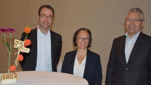 Elvira Pünchera vain bivgnanteda illa suprastanza da SRG.R da Nicola Pernet, directer RTR (a schnestra) e Vincent Augustin, president SRG.R (fotografia: Nicolo Bass).