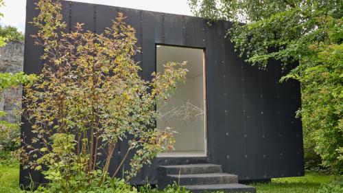 La «Chasina Naira» – ün pitschen local d’exposiziun zoppà tanter fluors illa giardinaria da Madlaina Lys e Flurin Bischof (fotografia: Michael Steiner).