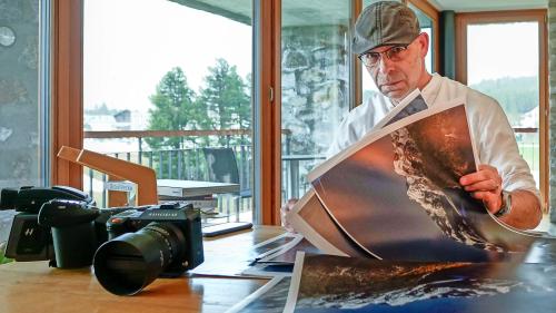 Der Fotograf, Gestalter und Kommunikationsfachmann Simon Walther sichtet in seinem «Basecamp» in Maloja
Vordrucke zum neuen Bildband «MondLichtbilder», welcher am 5. Juni erscheint. Foto: Jon Duschletta