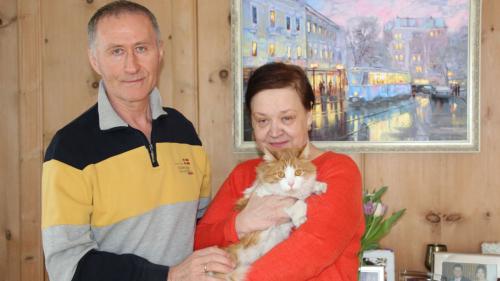 Irina Polhul und Anatolij Svartschevskij mit ihrer Katze Michelle in Samedan. Das Gemälde im Hintergrund zeigt die Stadt Winnyzja, in der Züritrams verkehren. 
