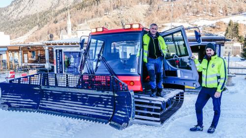 Michael Jenal (a schnestra) e Carlo Bott as mettan in posa cul Pisten Bully 100. fotografia: Jon Duschletta