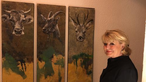 Monica Giarratana neben einer Tierporträt-Trilogie, die im Malojaner Hotel Kulm hängt.        Foto: Marie-Claire Jur