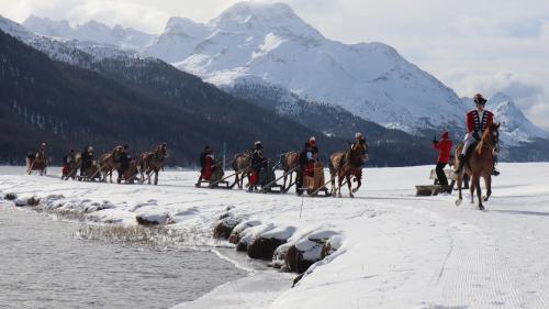 Ün cortegi da set schlittas, a la testa üna chavalgiaunta, es viagio in sanda passeda i’l ram da la schlitteda traunter San Murezzan e Silvaplauna (fotografia: Martin Camichel).