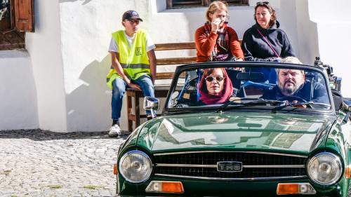 Bestatter Luc Conrad (Mike Müller) fährt mit seiner Berufskollegin Sonja Lardelli (Mona Petri) für Dreharbeiten durch Scuol. Foto: Jon Duschletta