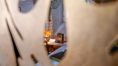 Blick durch eine Dekorationsschablone auf Exponate der Ausstellung «Die Uhr» im Kulturarchiv Oberengadin in Samedan. Foto: Jon Duschletta