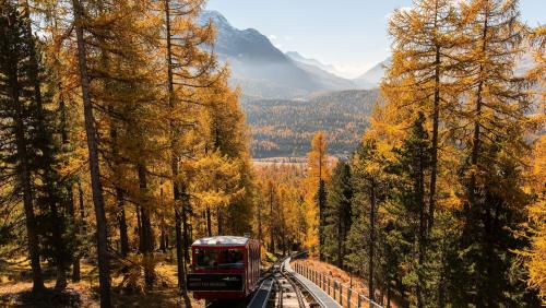 Die Muottas-Muragl-Bahn im ­herbstlichen Lärchenwald mit Blick auf die Oberengadiner Seenplatte. Beinahe schon ein Garant für touristische 
Höhenflüge. Foto: Engadin Tourismus