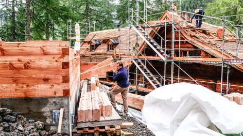 Umbau der Chamonna Cluozza: Links entsteht ein neuer Personal-Schlafturm und rechts wird das Haupthaus mit neuen Lärchenschindeln eingedeckt. Die Eröffnung ist für Juni 2022 geplant. Foto: Jon Duschletta